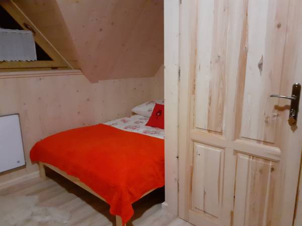 Pokój nr 2. Łóżko podwójne. Obok wyjścia na balkon dodatkowo znajduje się komoda.