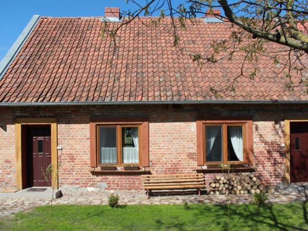 Dom od strony południowej. Od lewej: główne wejście, okno kuchni, okno dużego pokoju, drugie drzwi.