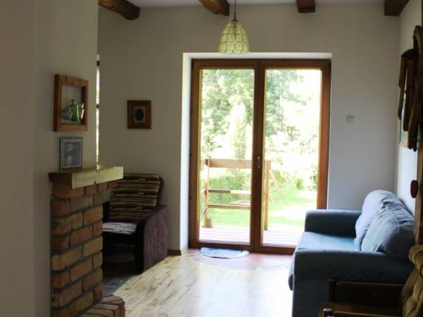 Z pokoju kominkowego wyjście na zadaszony taras z widokiem na jezioro Dejguny.