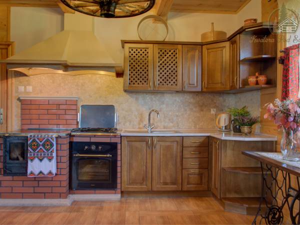 Aneks kuchenny wyposażony w tradycyjny wiejski piec oraz sprzęt AGD i niezbędne naczynia, gdzie można samodzielnie przygotowywać posiłki