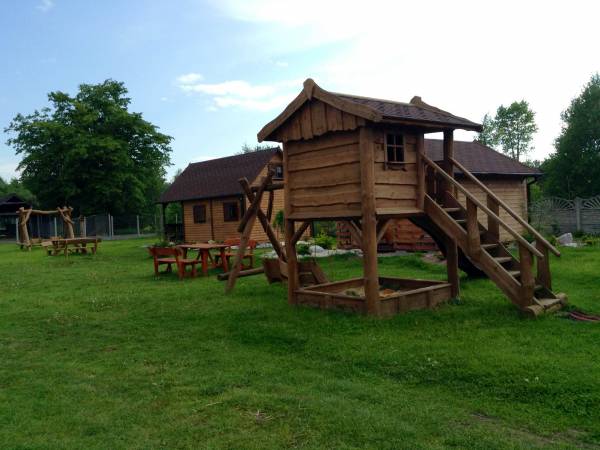 Plac zabaw dla dzieci z piaskownicą, huśtawką i zjeżdżalnią.