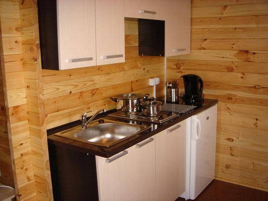 W kuchni lodówka, 2-palnikowa kuchenka elektryczna, czajnik, komplet garnków, zestaw sztućców, komplet obiadowy i kawowy