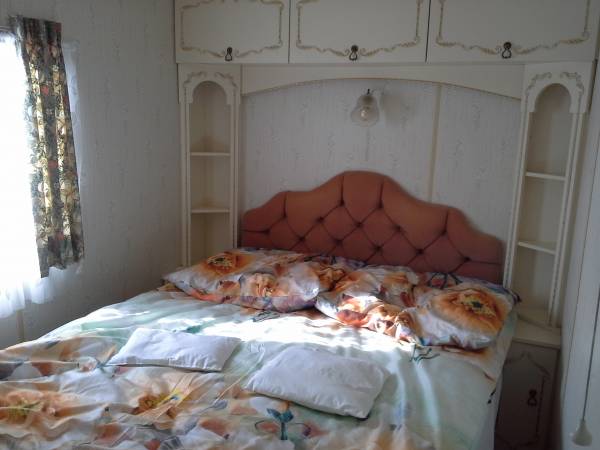 Sypialnia małżeńską wyposażoną w czystą pościel,kołdry i poduszki