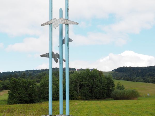 obelisk z lotniczymi emblematami, postawiony w 1974r., upamiętniający istniejące tu kiedyś szybowisko. Projekt obelisku wykonali  inż. S.Kondera i J.Zuzak.To u