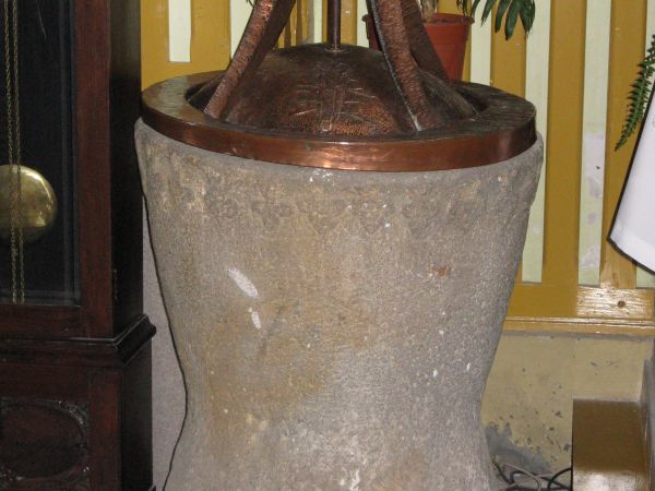 Chrzcielnica późnogotycka, koniec XV wieku, kamienna, w kształcie kielicha z arkadami i ornamentami w kształcie trójliści.