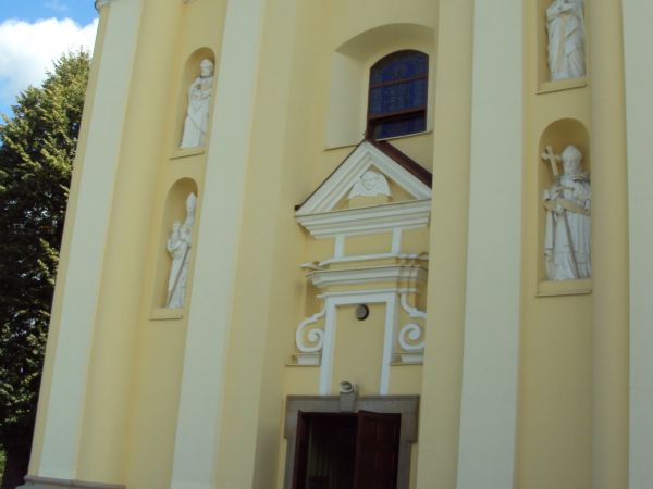 Przed kościołem pw. św. Mikołaja z 1 poł. XVIIIw. W fasadzie posiada dwie wieże, w niszach tych wież cztery rzeźby z XIXw. - dwóch św.św. biskupów oraz św.św. P