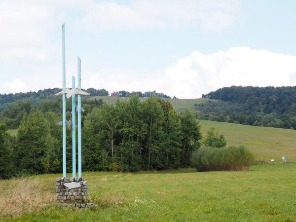 po prawej zbocze g. Słona Polanka - 631m npm wykorzystywane jako poligon szybowiska, zaś tu na przedzie : obelisk z lotniczymi emblematami, u podnóża lotniska,