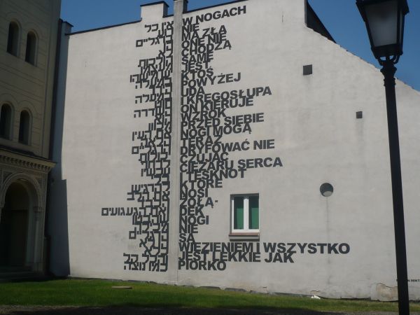 Na ścianie kamienicy przylegającej do  Synagogi ciekawostka wiersz  Izraelskiej poetki i tłumaczenie po Polsku.