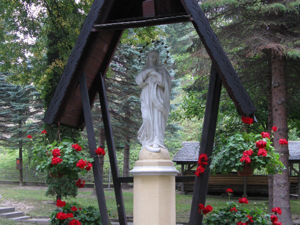 przed: w pobliżu kościoła XIXw. kamienna figura MB Niepokalanie Poczętej - ufundowana w 1880r. przez  Anielę Kraińską - żonę właściciela dworu i wsi, figura prz