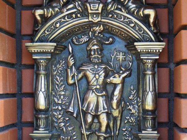 w kapliczce : scena ze św. Hubertem stojącym przy jeleniu, święty ten jest patronem myśliwych, leśników, strzelców a także lunatyków i chorych na epilepsję, wsp