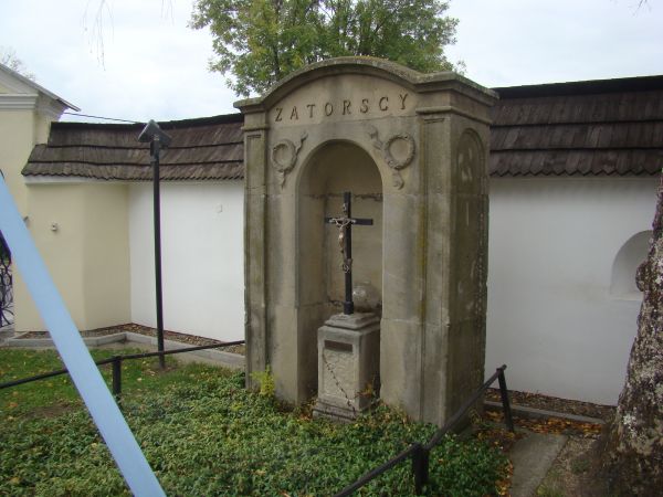 Pod murem obronnym,  okalającym kościół: kamienne nagrobki szlachty z okolicy, na zdjęciu: Cetolli Zatorskiej zm. w 1887r.