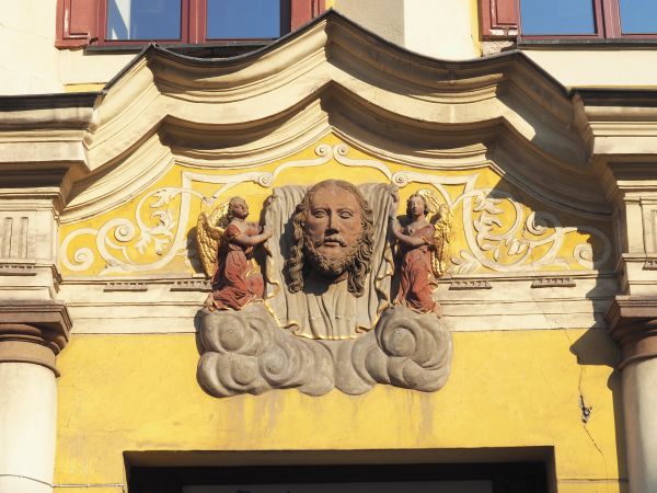 zabytkowa kamienica, fasada dekorowana płaskorzeźbami o treści religijnej, n/z w portalu przedstawiona głowa Chrystusa na płótnie - chuście św. Weroniki, zwane