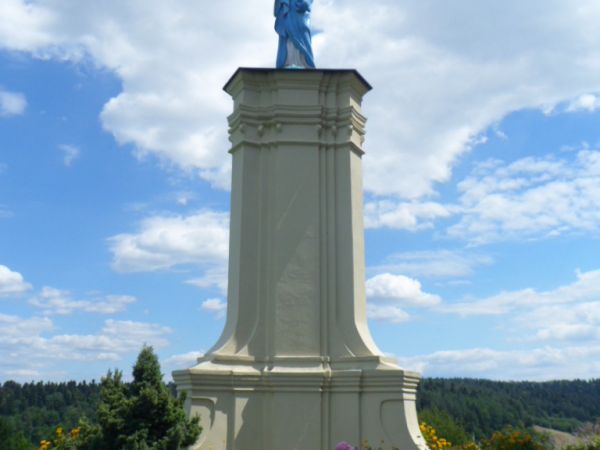 w zespole klasztornym - przed wejściem do kościoła - figura Matki Bożej z Dzieciątkiem, starannie odnowiona, otoczona opieką, zadbana, ukwiecona.