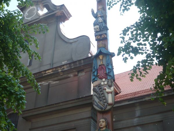 Przy kościele Św. Trójcy Krzyż Pawła Brylińskiego ludowego rzeźbiarza z 1858r.odnowiony w 2007r.