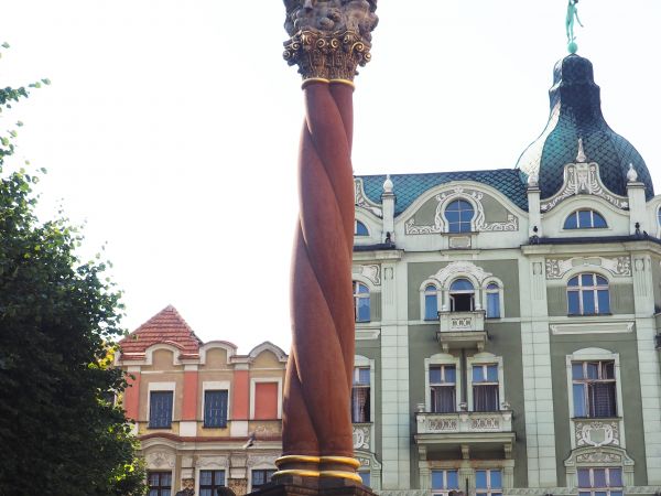 kolumna z przedstawieniem w zwieńczeniu Wizerunku Trójcy Świętej, z figurami postaci biblijnych, kartuszem herbowym.