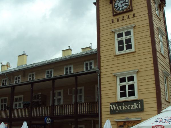 BAZAR - z lat 1876-1880, zbudowany na rzucie poziomym w kształcie zbliżonym do litery H z czworoboczną wieżą zegarową przy narożniku południowo- -zachodnim. Gór