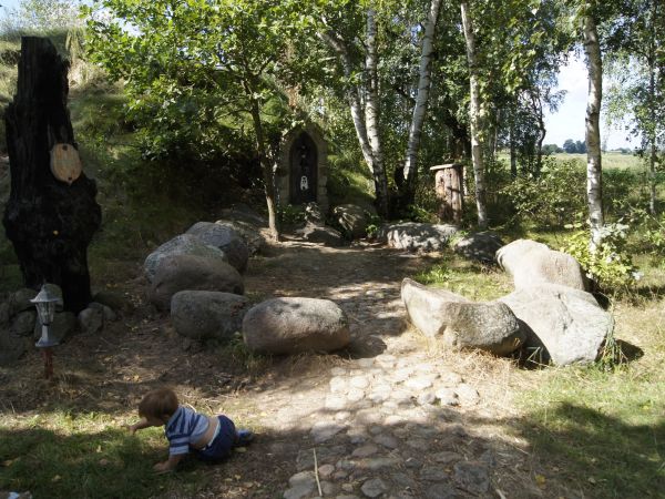 sierpień 2013 Lasek przy Jantarowym Kasztelu - Napis na tabliczce CZYŚ TY CHŁOPCEM CZY DZIEWCZĘCIEM ABY CHWYCIĆ SWOJE SZCZĘŚCIE  STĄPAJ Z WIARĄ PO KAMIENIACH DU