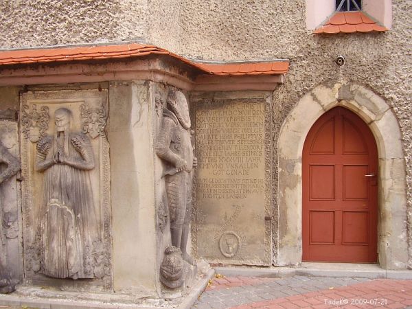 W mur kościelny wmurowane nagrobne płyty średniowieczne zdobiące południową ścianę