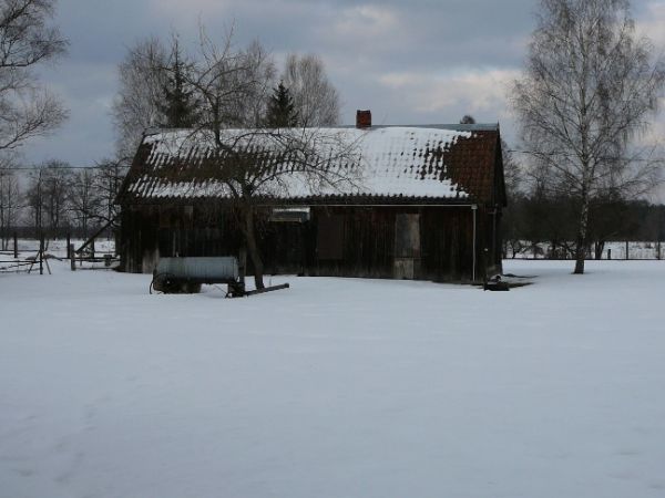 Mazurska drewniana chata wieczorową porą.