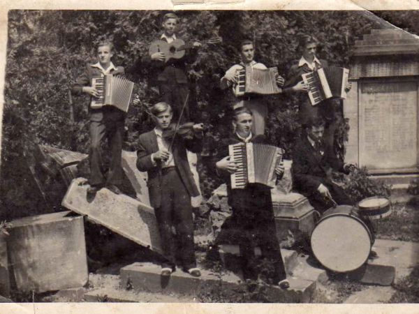 Zbylutów. Grupa młodzieżowego zespołu amatorskiego na tle niemieckiego pomnika, który został zburzony około 1950 roku. Pomnik stał naprzeciw obecnej Szkoły Pods