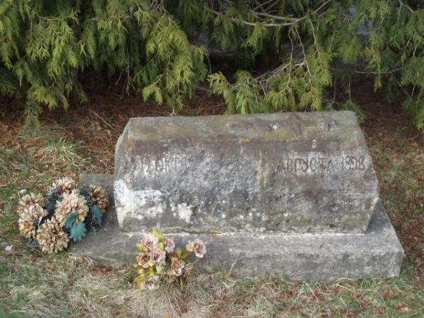 pomnik nagrobny z krzyżem greko-katolickim wyrytym w kamiennej bryle - przy cerkwi, użytkowanej jako kościół od 1971r.