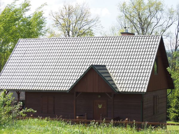 od strony lasu z zarazem od strony wsi - dziś wyludnionej - widok na domek myśliwski, po lewej widoczny fragment wolnostojącej wiaty ogniskowej - tam  kryty gon