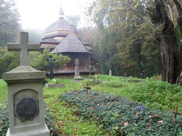 na wzgórzu przy cerkwi cmentarz - łany barwinka ukwiecają miejsca pochówków.