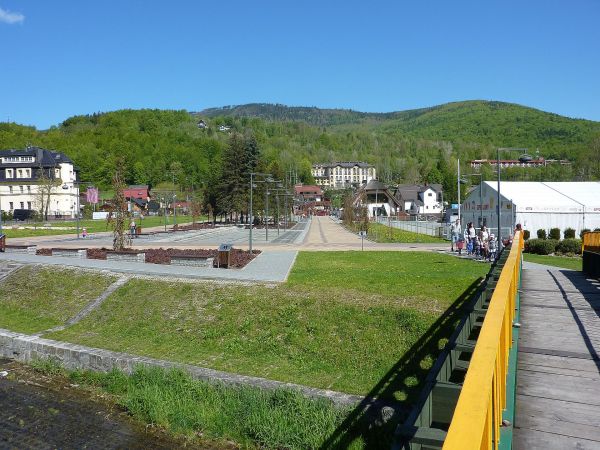 Deptak nad Żylicą zamyka plac od rzeki - przejście do ogrodu zabaw dla dzieci z trampolinami i dmuchanym zamkiem.