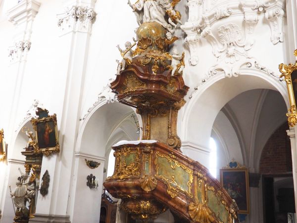 ambona - z obszerną kazalnicą, znakomity kunszt sztuki snycerskiej zdobiącej korpus oraz parapet i boazerię schodów a także baldachim.