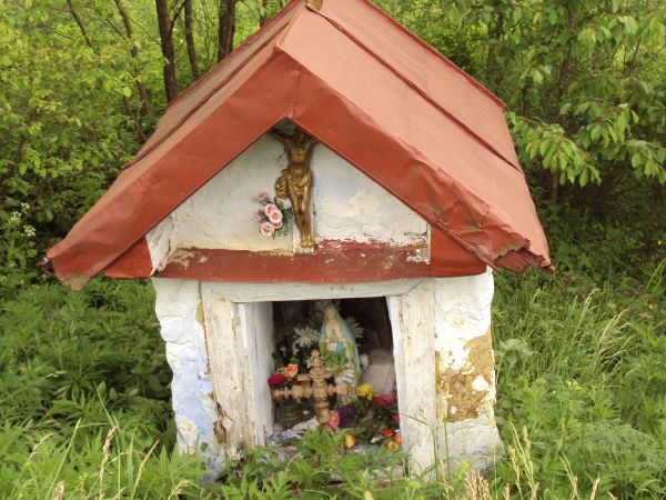 kapliczka przydrożna - pewnie "silnie wiekowa" , z krzyżem prawosławnym na dachu.