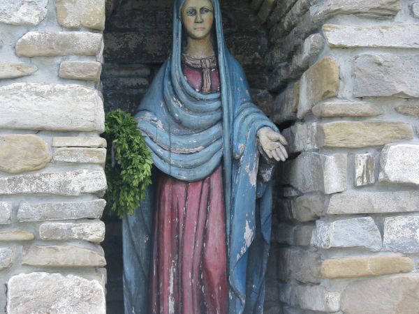 figura św. Tekli - w niebieskiej szacie, czerwonej sukni, o długich prostych, spadających na ramiona włosach, przykrytych zazwyczaj chustą, w większości ujęć -