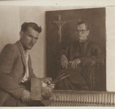 Włodzimierz Maślanka na tle malowanego przez siebie portretu Antoniego Adamiuka księdza urodzonego w Old Forge w Pensylwani/Stany Zjednoczone/,a będącego w lata