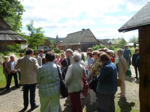 początkowy etap zwiedzania skansenu - n/z przewodnik przy planszy z mapą terenu i rozmieszczonych tam obiektach, dalej kamienny trakt prowadzi na Rynek Galicyjs