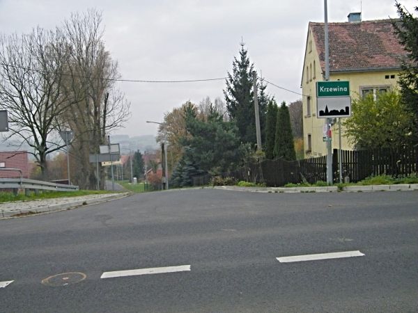 Droga chyba wojewódzka jej fragment a za nią początek wsi