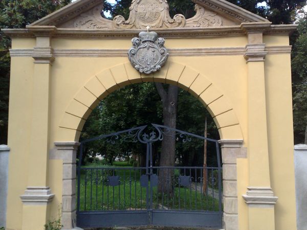 Zabytkowa barokowa brama wjazdowa, murowana z cegły, z przejazdem w formie arkady flankowanej przez pilastry toksańskie, z naczółkiem trójkątnym, przerywanym z