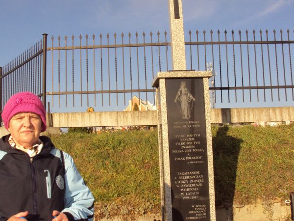 przed/obok - na zdjęciu: jak w opisie tablicy / krzyża.