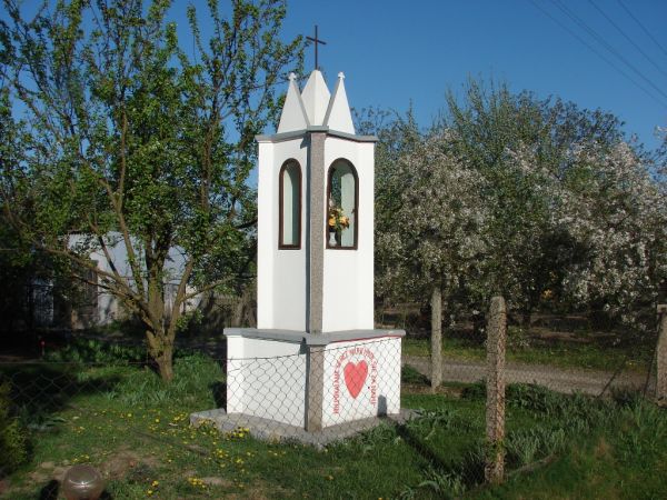 Kapliczka w przydomowym ogródku. We wnęce umieszczona jest ceramiczna figurka Matki Boskiej, a na cokole czerwone serce z napisem "Niepokalane Serce Marii módl