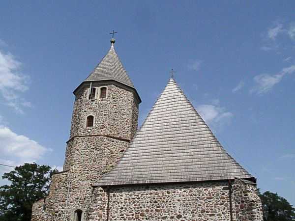 Kościół jest zbudowany z kamienia i pokryty drewnianym gontem