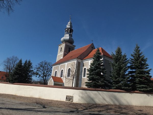 Kościół p. w Św. Marcina. Mur otaczający teren kościoła otynkowano zostawiając odsłonięty mały fragment aby ukazać ukrytą strukturę muru