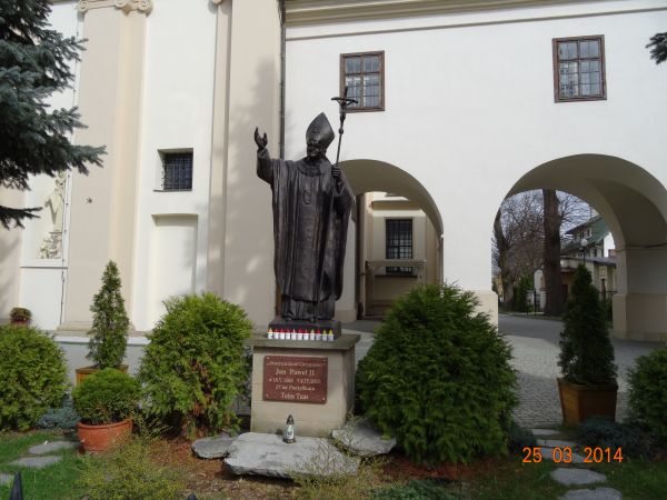 pomnik papieża św. Jana Pawła II - obok / przed kościołem, do którego przylega budynek dawnego kolegium mansjonarzy - z czasów, kiedy rezydowali tam biskupi prz