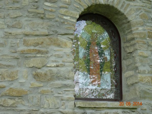 okno zamknięte półkoliście, w nim witraż - współczesne.