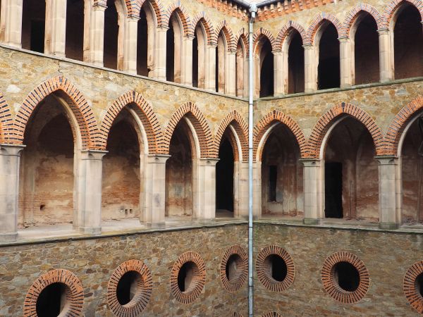 baszta obronna z krenelażem a niżej korytarze na kondygnacjach obiegające dziedziniec - ongiś były przeszklone i ogrzewane, na parterze zastosowano ponadto ogrz