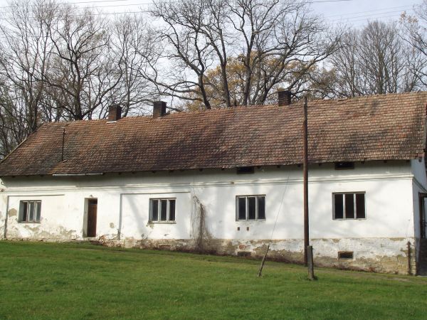 obok dworu: parterowa, murowana, częściowo podpiwniczona oficyna, z dachem dwuspadowym i szkarpami w narożnikach.