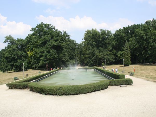 staw z fontanną w osi alei parkowej.