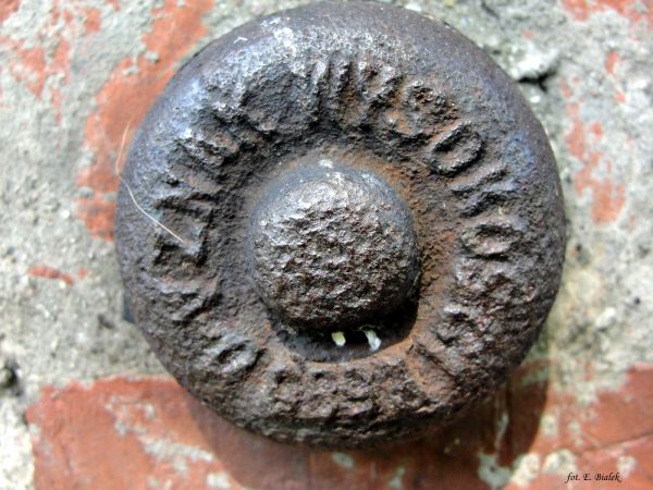 Reper wysokościowy na budynku starej szkoły.