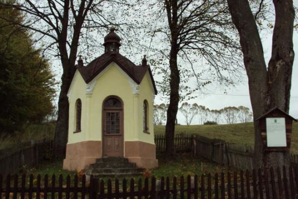 kapliczka - wzniesiona pod koniec XIXw., murowana, potynkowana, tzw. domkowa na rzucie ośmioboku. Zewnątrz w narożnikach półkolumny z główkami aniołków na kapit