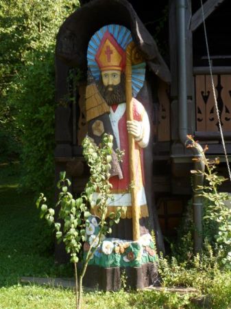 święty Ambroży - w aureoli, z pastorałem, z ulem - szlachetnie odziany a na szatach przedstawiony Orzeł Polski a u stóp kwiecia wiele - bo pszczółkom konieczne