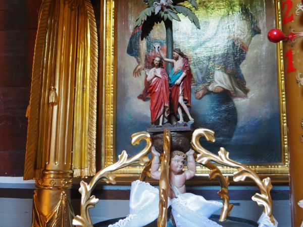 zwieńczenie pokrywy kielicha chrzcielnicy - eksponowanej pod baldachimem, dalej rzeźba Chrztu Chrystusa przed obrazem przedstawiającym Trójcę Świętą.