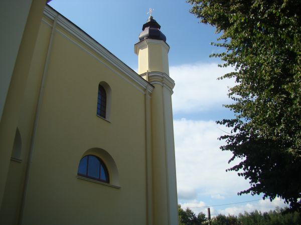 ściana boczna kościoła, z otworami okiennymi i zdobieniami gzymsów.