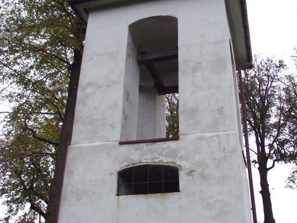 murowana, potynkowana, na rzucie kwadratu - dolna kondygnacja przepruta bramką : dzwonnica cerkiewna, położona na wzniesieniu, w wieńcu starych drzew. Zwieńczon